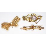 A group of three brooches; one of bow form and set with split pearls, hallmarked 9ct gold, the other