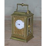 A late 19th century brass repeat carriage clock, etched brass with round enamel dial having Roman