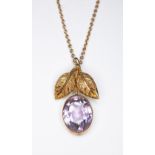 An amethyst pendant, the millegrain bezel set oval mixed cut amethyst set below two leaves,