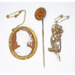 A mixed lot of jewellery comprising a shell cameo brooch marked '9', a yellow metal stick pin and