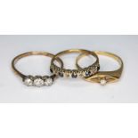 A group of three rings comprising a three stone diamond ring marked 'PLAT', a hallmarked 9ct gold