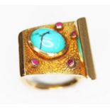 A modernist turquoise and ruby ring, textured and shaped scroll set with a central turquoise