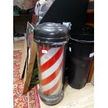 A barber shop red and white striped revolving pole.