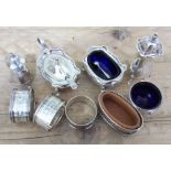 A mixed lot of hallmarked silver comprising a three piece cruet, three serviette rings, two salts
