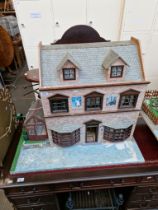 A three storey dolls house with furniture & contents.