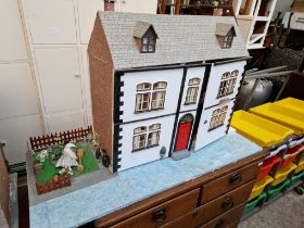 A two storey dolls house with furniture & contents.