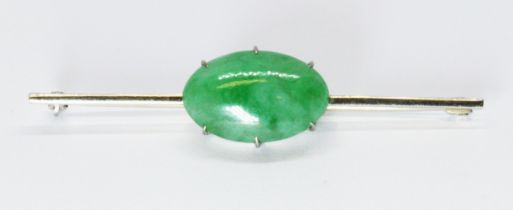 An early 20th century jadeite jade cabochon bar brooch, the oval slightly convex bottom cabochon
