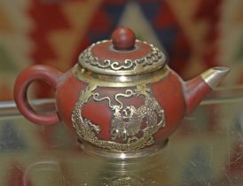 A Chinese white metal mounted miniature Yixing red clay teapot and cover, seal mark to base,