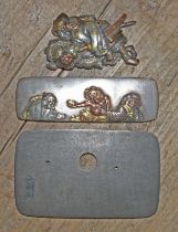 Three pieces of Japanese metalware comprising two mixed metal katana menuki; one depicting two