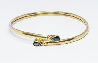 A hallmarked 9ct gold sapphire bangle, wt. 7.9g, diam. 6cm. Condition - general wear.