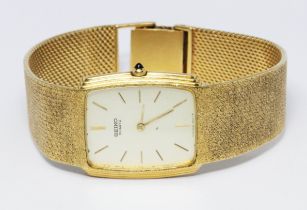 An 18ct gold Seiko wristwatch, case width 26mm, with 18ct textured gold strap, gross wt. 77.4g.