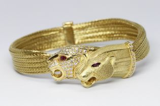 A diamond and ruby panther bracelet, twin panther heads, one with pave set diamonds to face, the