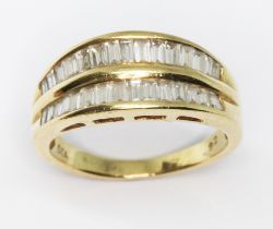 An 18ct gold diamond ring, two rows of channel set baguette cut diamonds weighing approx. 0.92cts in