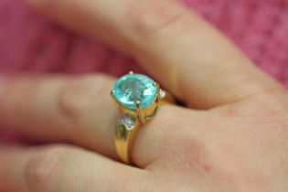A paraiba tourmaline and diamond ring, the oval mixed cut tourmaline weighing approx. 5.47cts,