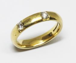 An 18ct gold diamond wedding band, two round brilliant cut stones weighing approx. 0.10cts each,