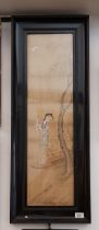 A framed Japanese painting on silk depicting a woman on a boat.