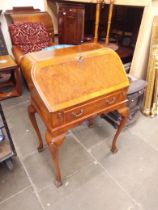 A reproduction Queen Anne style burr walnut bureau.