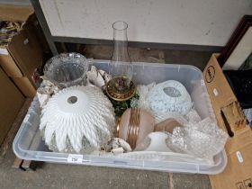 A box of glass light shades and a Victorian oil lamp.