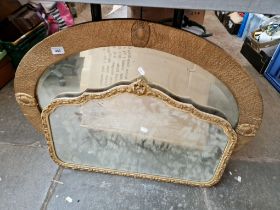 An oval gilt framed mirror and an over mantle mirror