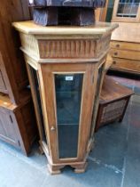 An hexagonal glazed display cabinet.