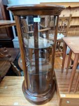 A cylindrical glass display cabinet.