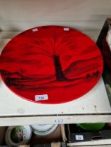 A Peggy Davis Ceramics red glazed charger decorated with palm tree, original artists proof.
