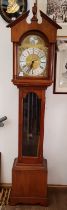 A reproduction long case clock with brass dial, weights and pendulum.