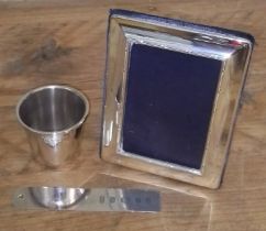 Hallmarked silver comprising a shot measure, a bookmark and a photograph frame.