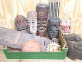 A box of assorted wooden, pottery and metal masks.