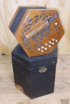An antique accordion squeeze box with hard case.
