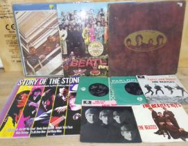 Four vinyl LP records and five vinyl singles, mostly The Beatles and one Rolling Stones.