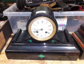 A black slate mantle clock with malachite inlay.