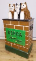 An RSCPA collection box modelled as three cats, each for a milk bottle and sat on a wall, height