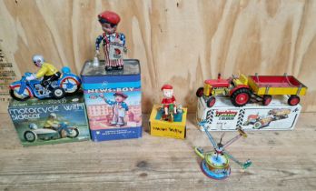 A box of assorted clockwork tin toys comprising of a Fossil news boy, motorcycle with sidecar,