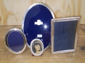Three silver photograph frames and another.