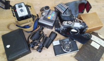 A mixed lot comprising cameras, a box of slides, a pair of binoculars and military eyeshields.