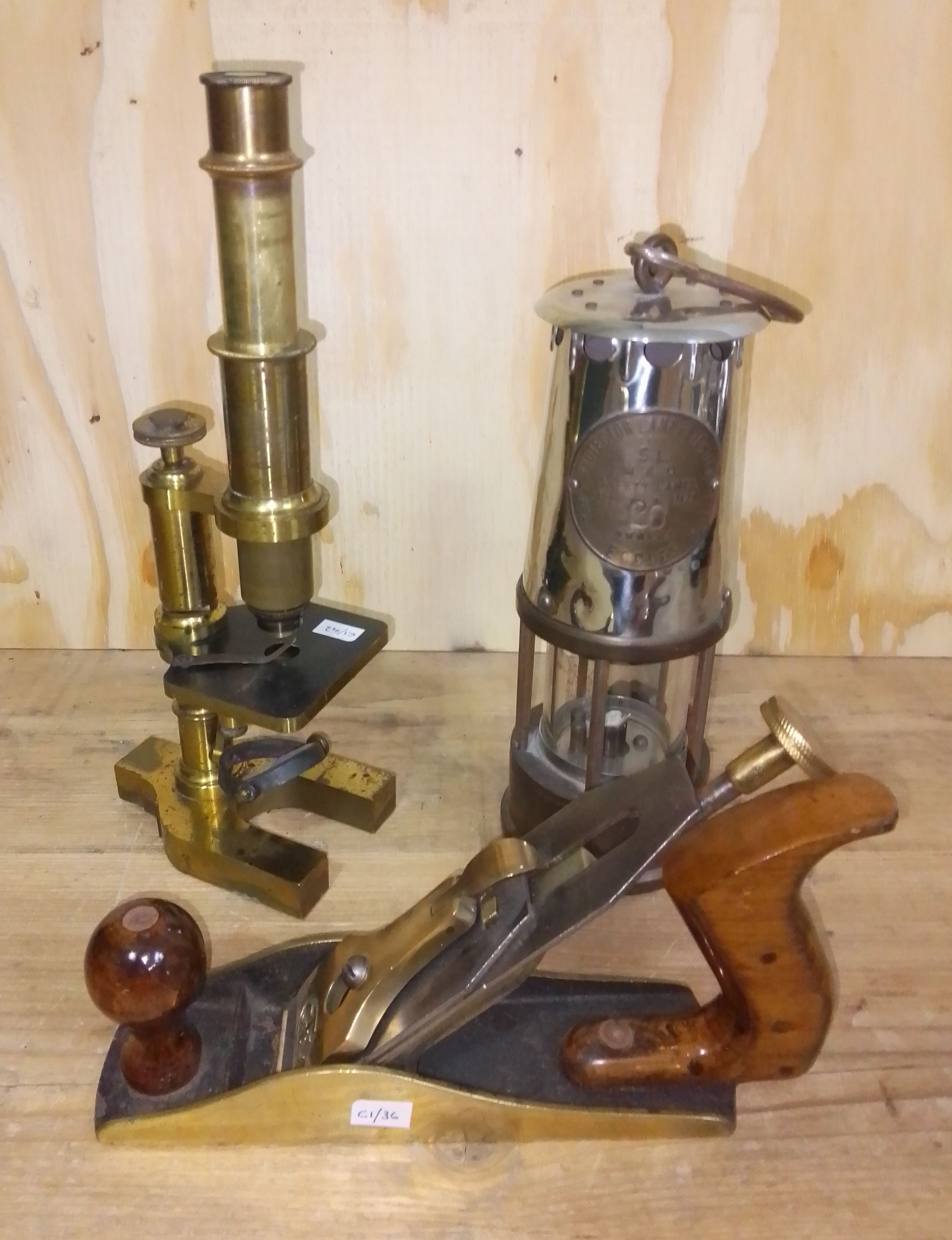 A mixed lot comprising a pit lamp, a plane and a microscope.