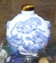 A Chinese porcelain snuff bottle, embossed with foh dogs, tiger's eye top, Guangxu six character