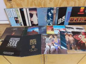 A box of approximately 30 LP vinyl records including Phil Colins, Eddy Grant, Simple Minds, The