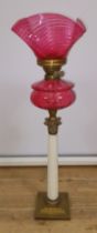 A Victorian cranberry glass oil lamp, ribbed shade, Duplex fitting, cranberry reservoir,