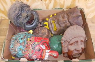 A box of assorted pottery, wooden and metal masks.