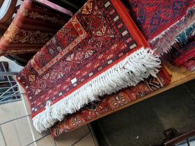 Three eastern style red ground wool carpets