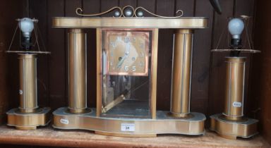 A 1930s Art Deco mantle clock with electric lamp garnitures.