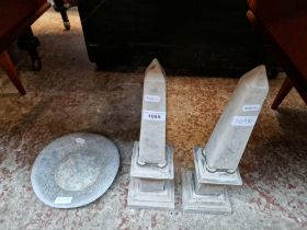 Two concrete obelisks and a stone dish.