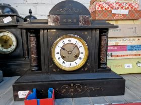 A black slate mantle clock with pendulum and key.