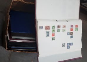 A box of assorted stamp albums to include mint stamps.