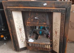 An Art Nouveau cast metal fireplace insert with original tiles..