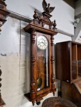 A walnut cased Vienna wall clock complete with weights, pendulum and key.