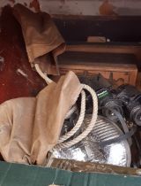 A box of assorted items including binoculars, a vintage rope swing, head lamp etc.