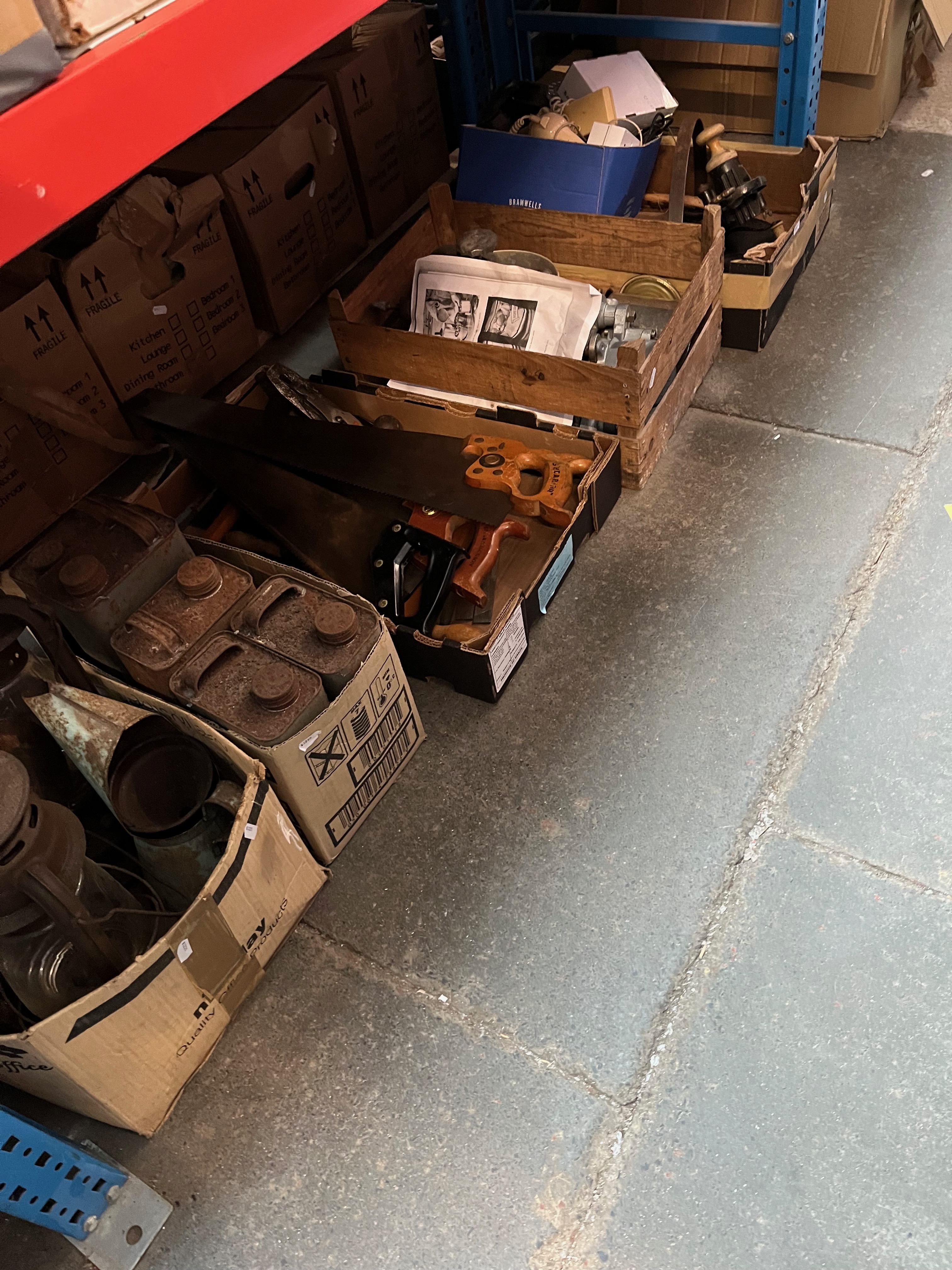 A box of vintage metalware - oil lamps, oil pourer, 5 tins of water repellent, 5 wood saws, a